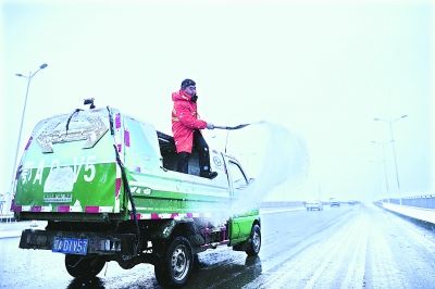  昨日8时30分，洪山城管局机扫队的队员在野芷湖大桥撒盐化雪 记者周超 摄(信息来源：雷霓雰) 